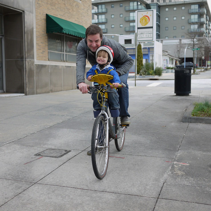 child learning to ride a bike on handlebars 