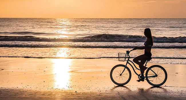 sunrise beach bicycle rider a bicycler enjoys the benefits of biking on a sunrise beach cruise