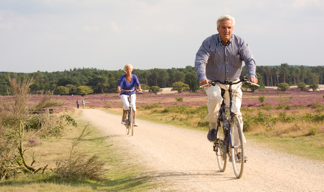 older couple bike riding couple shows a healthy bike benefit is that you can do it at any age